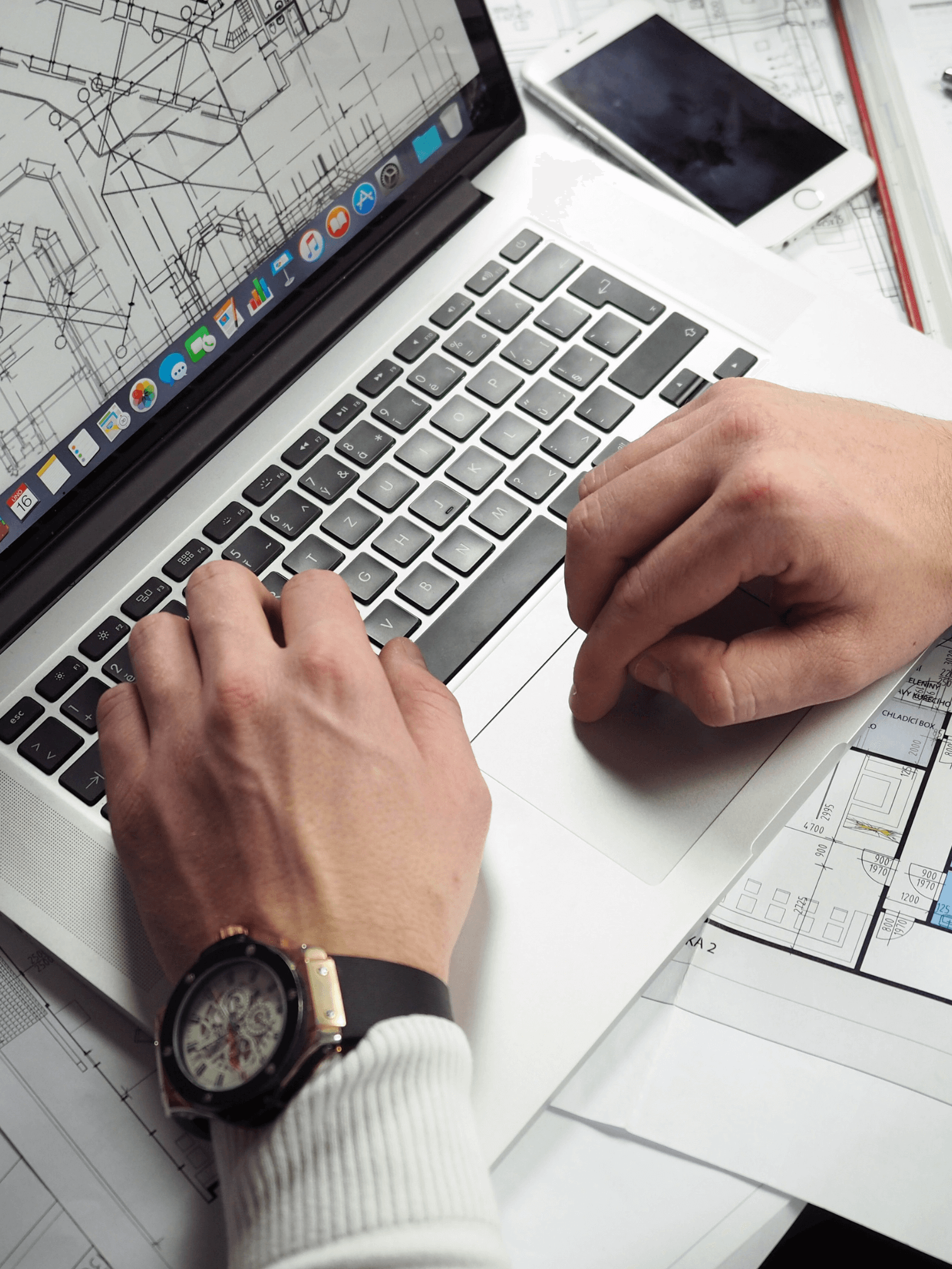 A man on his computer looking at architectural plans looking to get his estimate ready