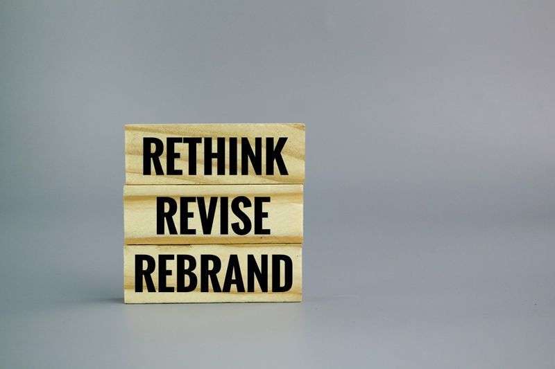"Rethink, Revise, Rebrand" spelled out on stacked wooden letter blocks, representing a company rebrand