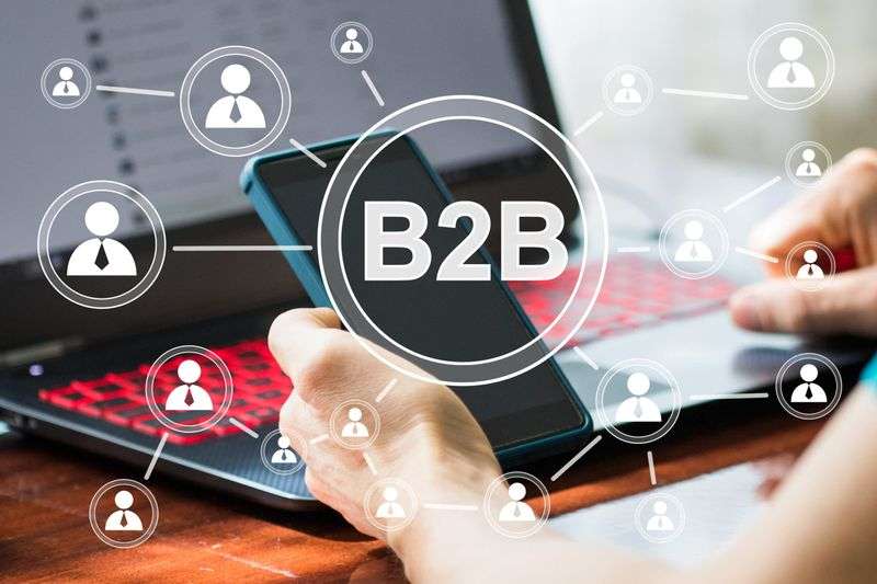 "B2B" text surrounded by connected contact network icons above a laptop and smartphone