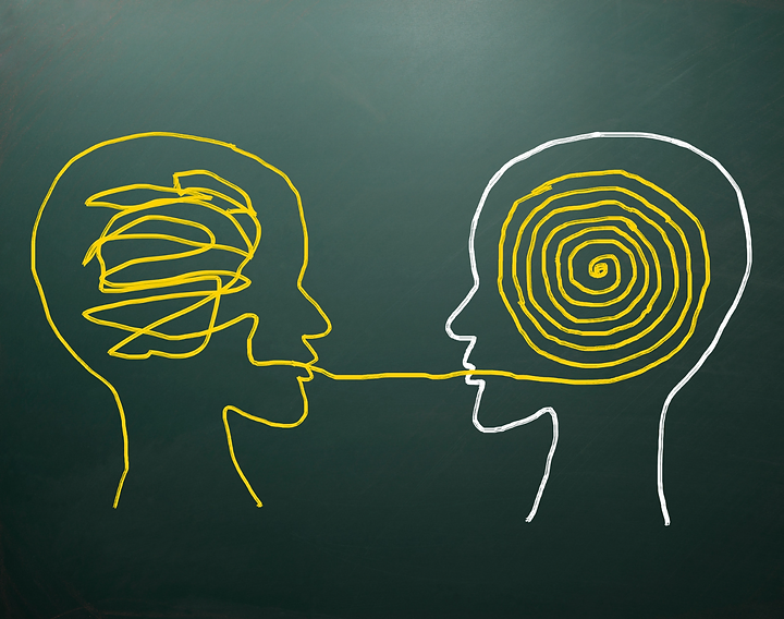 Chalkboard illustration of two heads communicating, representing clear messaging in construction marketing