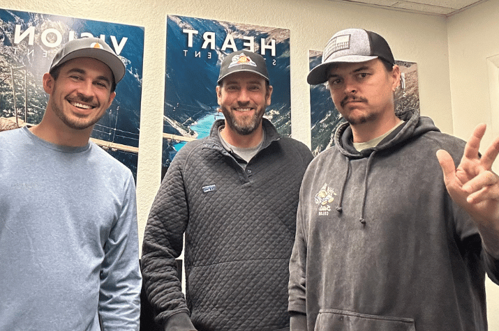 Three Ideal Rev construction sales team members posing together in the office